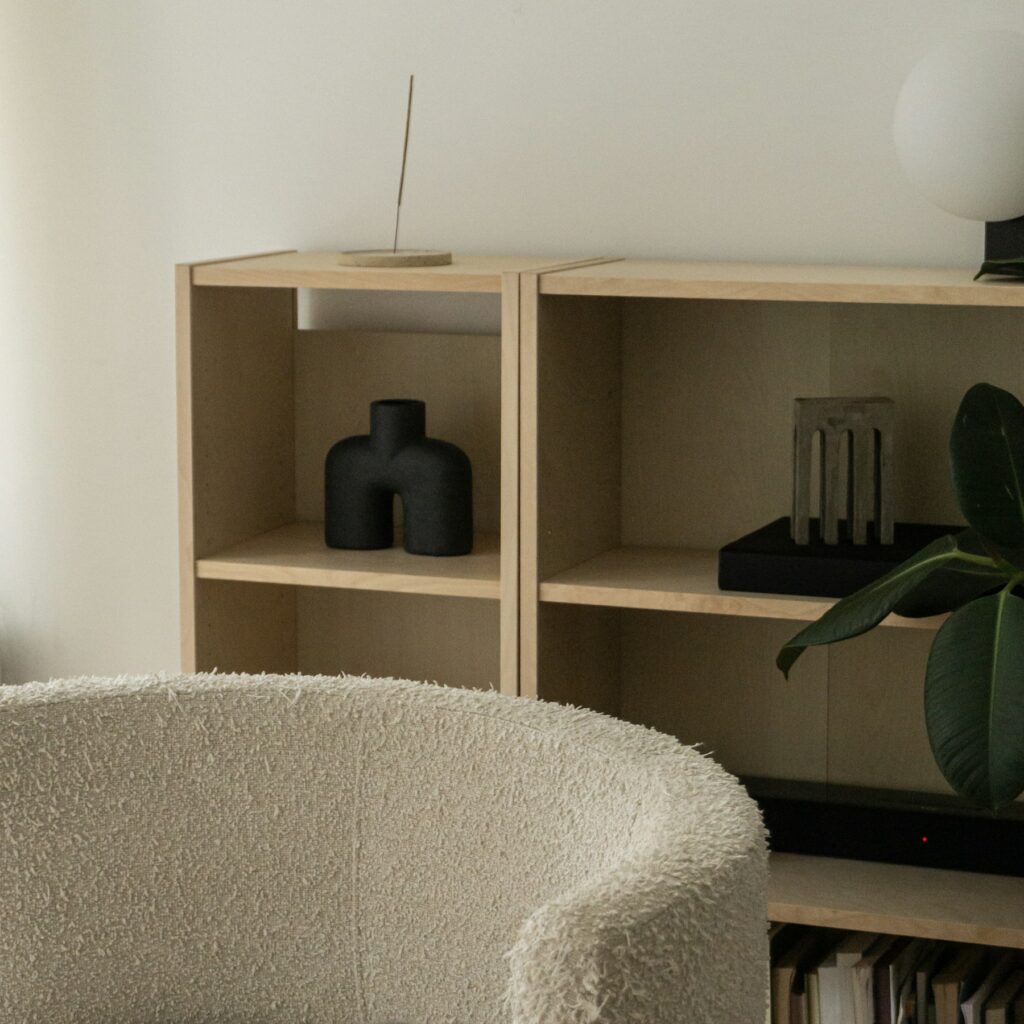 a living room with a white chair and a book shelf